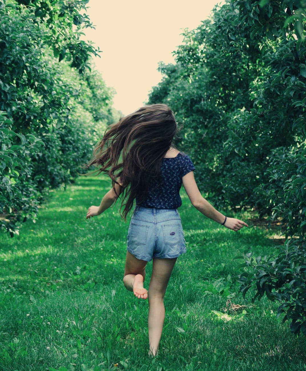 photo of a woman running on green grass